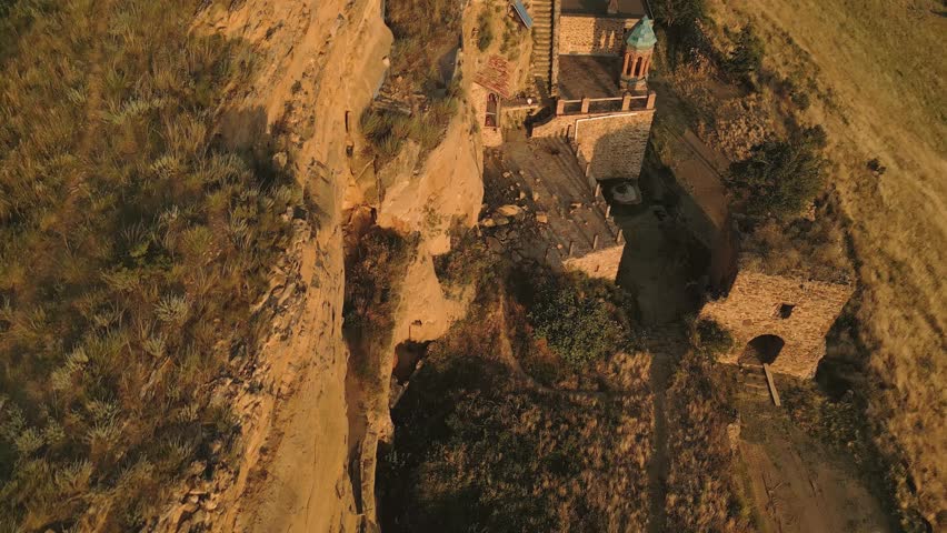 Aerial view Natlismtsemeli Monastery complex carved into cliffs, medieval Georgian Orthodox architecture in remote Kakheti hills. Part of David Gareja monastic complex. Azerbaijan Georgia border zone