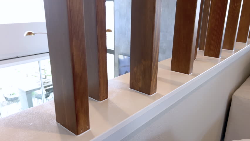 Side view of vertical wooden slats used as a partial divider between a living room and adjacent area. The design adds architectural interest and maintains an open feel.