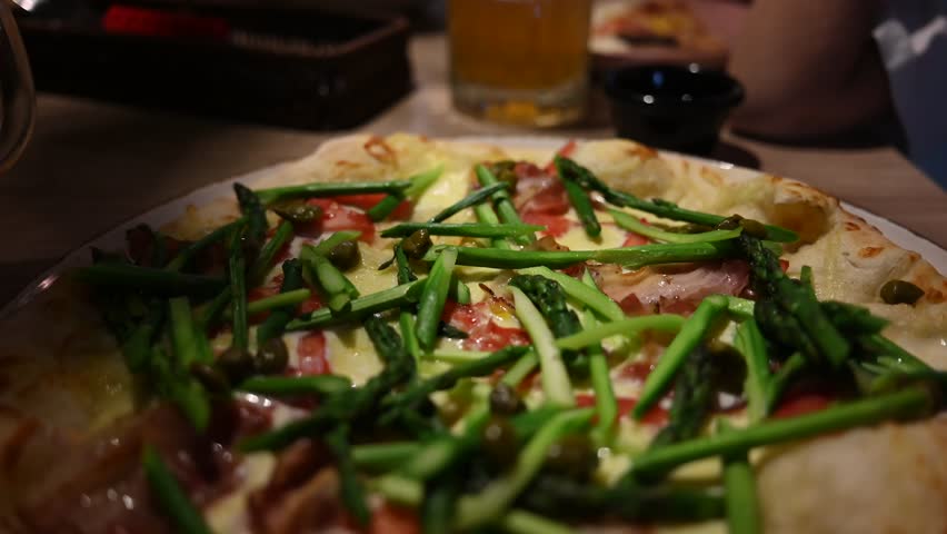 A Delicious Gourmet Pizza Topped with Fresh Asparagus, Savory Bacon, and Melted Cheese.