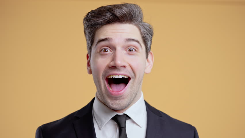 Handsome mature businessman reacts with amazed expression, says wow, open mouth