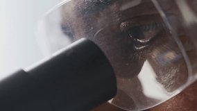 Eyes of male scientist in safety goggles looking through microscope eyepiece during laboratory analysis. Extreme close-up view - Powered by Shutterstock - Get 15% off with code: PIKWIZARD15