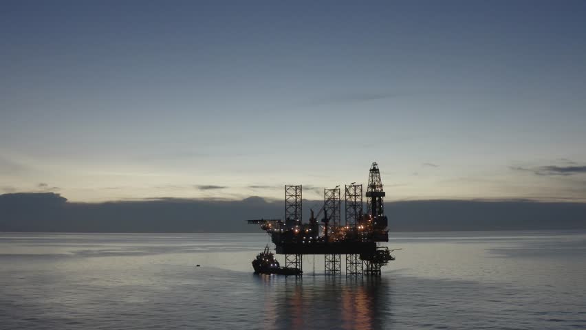 Areal view of offshore jack up rig and offshore platform during sunset for oil and gas exploration and production. 

