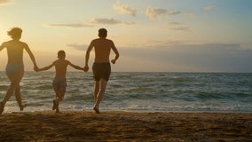 Happy family runs into ocean waves at sunset, enjoying vacation and splashing water. Perfect for travel, leisure, and family bonding concepts. - Powered by Shutterstock - Get 15% off with code: PIKWIZARD15