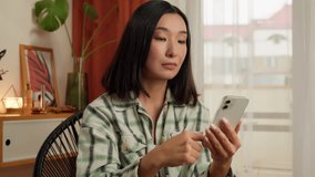 Shocked upset Asian Korean woman holding mobile phone smartphone reading bad news message stressed female frustrated girl fail problem negative worried sad businesswoman home indoor lose online credit - Powered by Shutterstock - Get 15% off with code: PIKWIZARD15