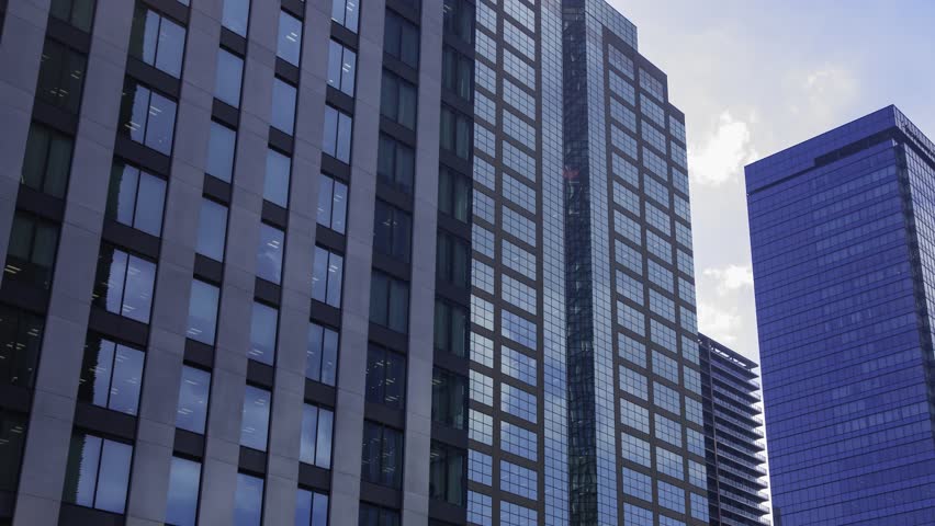 A timelapse of moving cloud reflecting the office building at the city wide shot