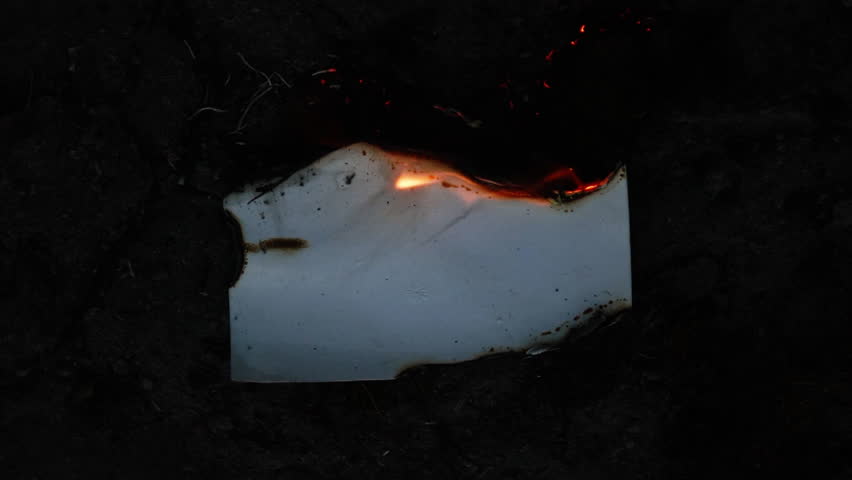 Burning and glowing photo or paper with fire flame and smoke on dark background