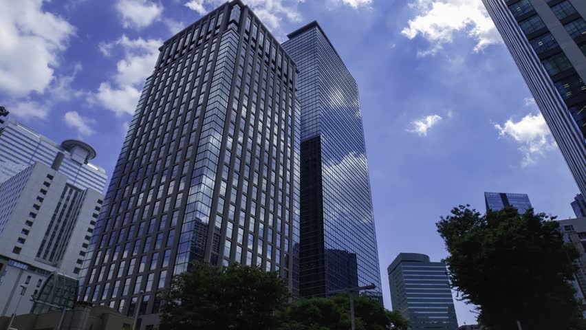 A timelapse of moving cloud reflecting the office building at the city wide shot
