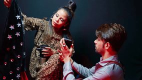 Model watches attire image on phone as holding jacket, Photographer Shares Outfit pic via Mobile, Trendy lady gripping coffee mug takes coat appreciating, Girl heads off to change look, Man in harness - Powered by Shutterstock - Get 15% off with code: PIKWIZARD15