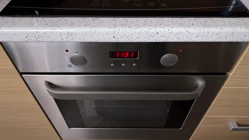 Top view the man turns on the electrical oven in the kitchen to cook food. Preparing to cook food.