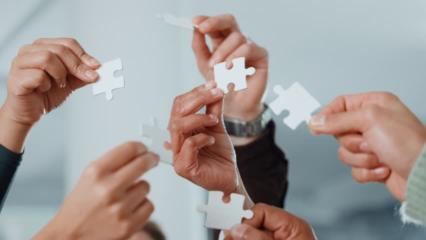 Puzzle, hands and business people in office for collaboration, problem solving or cooperation. Jigsaw, teamwork and group of corporate employees with solution, planning or synergy in workplace.