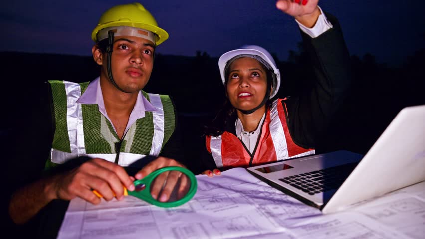 Two construction workers examine blueprints under twilight, Female project head explains layout beside laptop, Forewoman highlights map on screen, Male Architect uses magnifying glass to check design