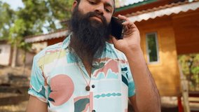 Rugged traveler speaks leisurely by smartphone outdoor, Bearded man talk on mobile at peaceful retreat, Day tripper takes call during scenic break, Vacationer in casual attire uses phone, Tourist zone - Powered by Shutterstock - Get 15% off with code: PIKWIZARD15