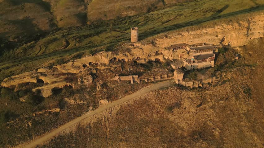 Aerial view Natlismtsemeli Monastery complex carved into cliffs, medieval Georgian Orthodox architecture in remote Kakheti hills. Part of David Gareja monastic complex. Azerbaijan Georgia border zone