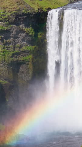Aerial Skogafoss Waterfall in Iceland, complete with a rainbow view. Vertical