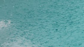 Heavy rain is falling on turquoise water surface, creating ripples, splashes, and mesmerizing texture, evoking sense of tranquility and power of nature. Raindrops dancing on dreamy lagoon - Powered by Shutterstock - Get 15% off with code: PIKWIZARD15
