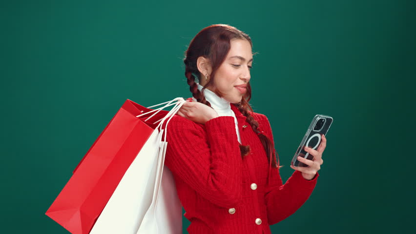 Christmas, girl or selfie with shopping bags in studio for holiday gifts, social media post or promo. Happy, woman or photograph with xmas presents for festive sale or celebration on green background