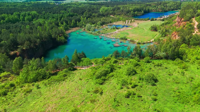 Aerial view of Park Grodek in Jaworzno, Southern Poland. Known as the Polish Maldives, the park features turquoise lakes in a former quarry, wooden walkways, and lush natural surroundings.
