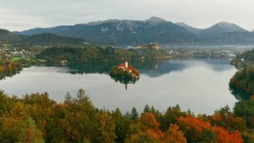 Aerial view of Lake Bled at sunrise in autumn, Slovenia. Scenic landscape with Pilgrimage Church on the island and medieval Bled Castle on a cliff above the picturesque lake surrounded by mountains. - Powered by Shutterstock - Get 15% off with code: PIKWIZARD15