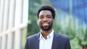 Portrait of smiling african american businessman in formal suit standing on street near office building. Happy male entrepreneur looking at camera. Head shot confident manager posing outside. Close up - Powered by Shutterstock - Get 15% off with code: PIKWIZARD15