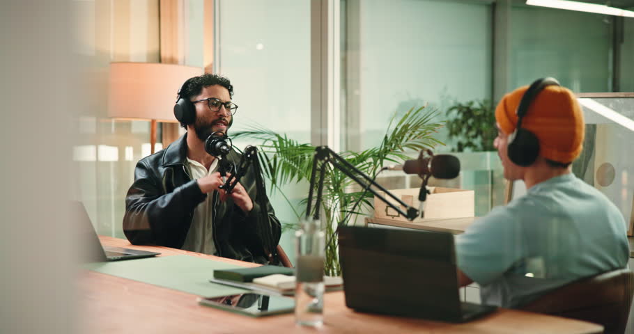 Podcast, interview and men with mic in studio, content creation or live stream of discussion on web. Happy, podcaster and talking to guest with headphones, online and conversation with influencer