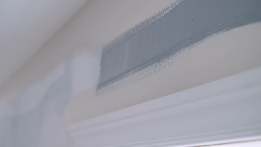 Female Homeowner Engaged In Peaceful Redesign Task, Updating Wall Paint And Contributing To The Comfort Of Her Living Area. Calm Renovation Moment With Woman Painting Wall Inside Her Apartment