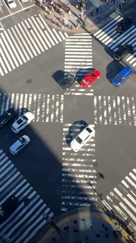 Timelapse of aerial view over a traffic cars and a crowd of pedestrian crossing street. Elevated view over an asian people locals and tourists walking in busiest road intersection.