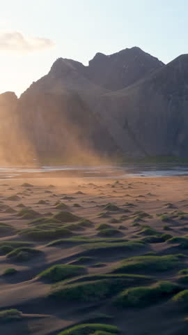 The aerial view of Mountains and Expansive, Lush Green Dyunes Nearby. Stokksnes. Iceland. vertical video