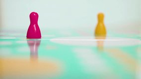A white game dice rolls across a glossy turquoise board, passing pink and yellow pawns with shallow depth of field. The forward motion highlights randomness, strategy and excitement in tabletop gaming - Powered by Shutterstock - Get 15% off with code: PIKWIZARD15