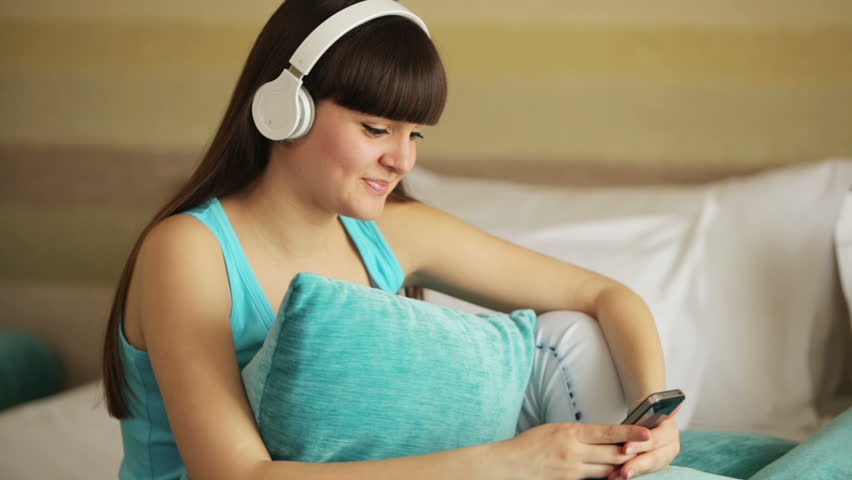 Girl listening music and looking at camera with smile

