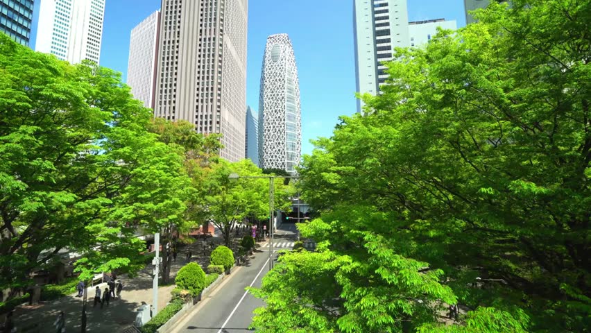 Lush green trees frame modern buildings in tokyo