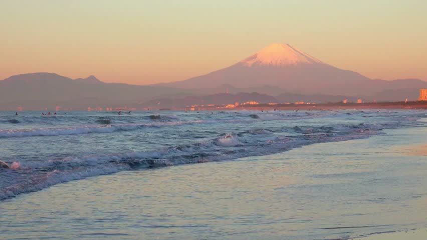 Mount fuji rises above the ocean at sunset