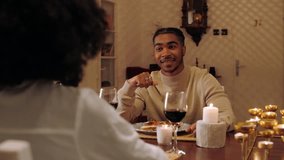 Romantic candlelit dinner scene with young couple sharing wine, engaging in intimate conversation with soft, warm ambiance - Powered by Shutterstock - Get 15% off with code: PIKWIZARD15