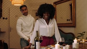 Young couple enjoying a romantic dinner at home, sharing laughter, wine, and intimate moments by candlelight - Powered by Shutterstock - Get 15% off with code: PIKWIZARD15