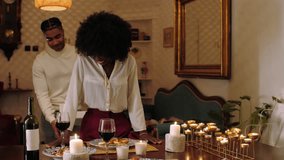 Young black couple enjoying a romantic dinner at home, sharing wine, food, and intimate conversation by candlelight - Powered by Shutterstock - Get 15% off with code: PIKWIZARD15