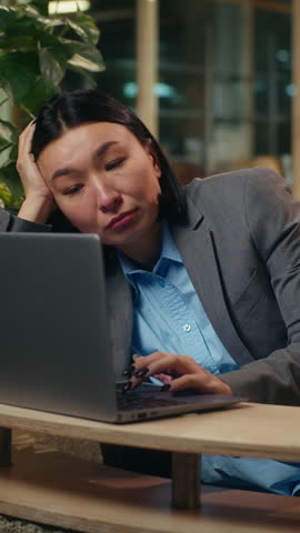 Tired bored Asian Korean Chinese Japanese woman female sad upset girl businesswoman business office fatigued unmotivated worker laptop employee indoor boring computer work lazy manager working burnout