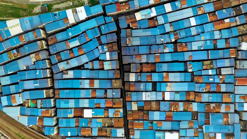 Huaanli shantytown in Wuhan is shown from above, featuring densely packed structures with blue roofs before its imminent demolition and transformation for urban development.