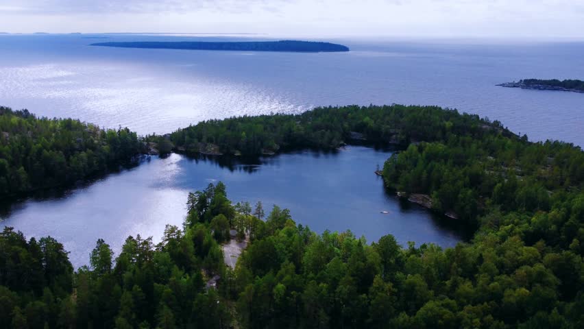 Russia, Lake Ladoga, Koyonsaari. View of the coast of the island in a cold lake. Beautiful nature of the Republic of Karelia. Panoramic view from the height of the Ladoga skerry islands. 4K