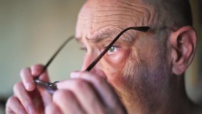 A contemplative senior man wearing glasses, captured in a reflective mood. The soft lighting emphasizes the details of his face, evoking emotions of thoughtfulness, introspection, and life experience. - Powered by Shutterstock - Get 15% off with code: PIKWIZARD15