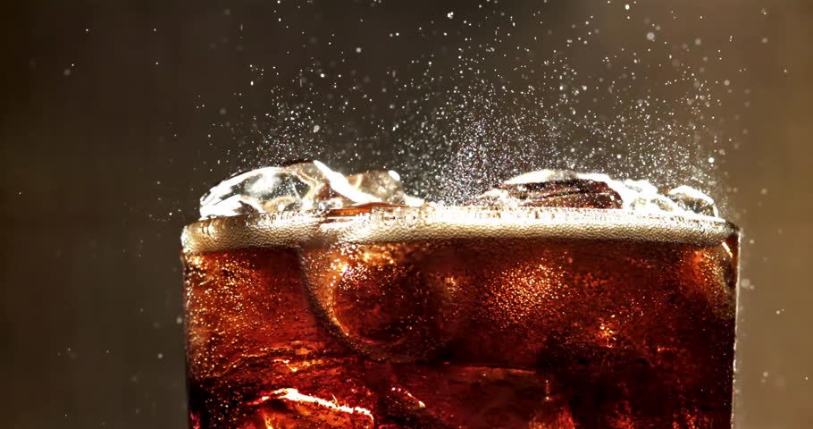 Slow Motion Close-Up of a Cool Refreshing Drink with Ice Cubes and Fizzy Bubbles in a Transparent Glass – Real-Time Footage Capturing the Chill, Sparkle, and Refreshment of a Carbonated Beverage on 