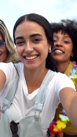 Diverse group of young women sharing genuine moments of joy, capturing friendship through candid selfie during summer outdoor adventure