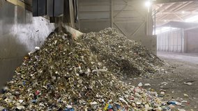 Conveyor sorting small waste accumulates various types of waste in a pile. Tractor with bucket loader loads mixed biomass and small residues into repository sarcophagus storage for further processing - Powered by Shutterstock - Get 15% off with code: PIKWIZARD15