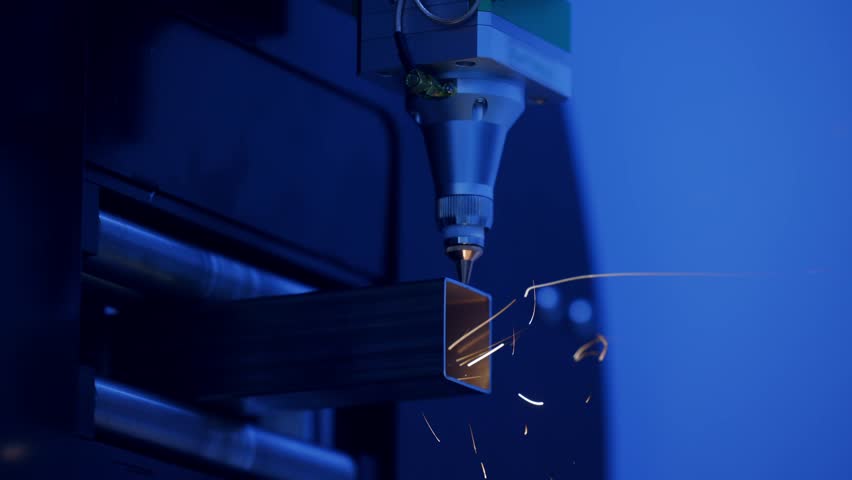 Precision laser cnc cutting metal with sparks emitting light.