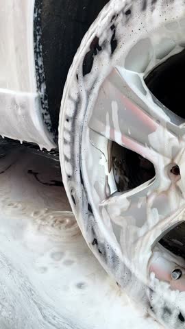 This highquality footage showcases the foam application process in a car wash, highlighting shiny wheels and soap suds for an exceptional cleaning experience that enchants viewers