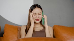 Young asian woman sits on a couch, she listens intently to her friends or family. Heartfelt words echo, revealing her sorrow and empathy, sad, frustrated, upset, failure, bad news stress, bankruptcy - Powered by Shutterstock - Get 15% off with code: PIKWIZARD15