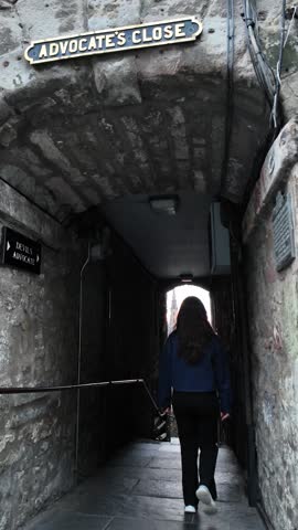 Young female tourist walk in a close street which is subject of horror stories during the black plague in Edinburgh.