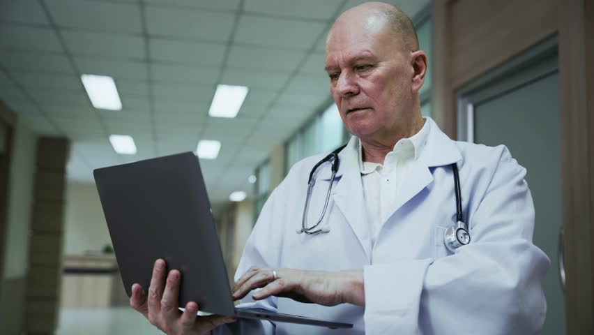 A male doctor uses a laptop with advanced AI and digital interface to analyze health data and plan patient treatment.