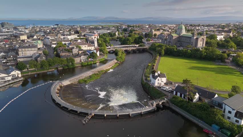 Aerial scenic views of Galway's River Corrib and city landscape on a sunny afternoon in summer. Fly over Galway, Ireland
