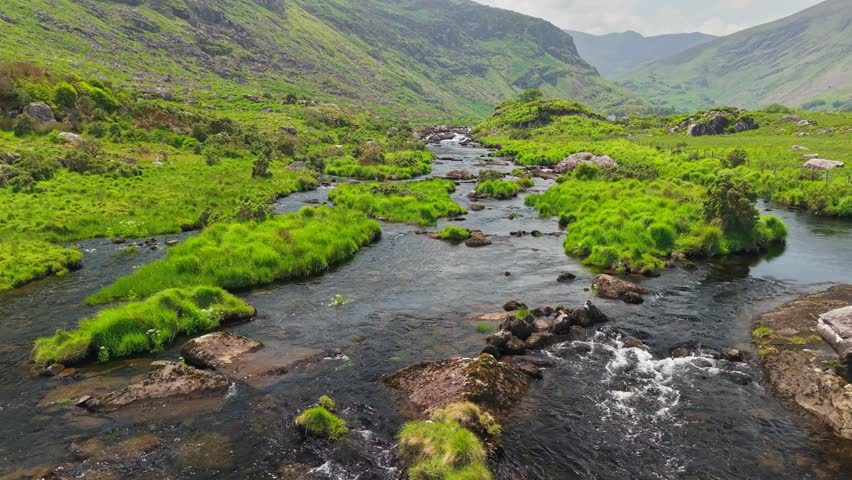 Flying over river in valley between mountains Killarney National Park, Ireland, County Kerry. Nature of Ring of Kerry, Ireland. Aerial shot