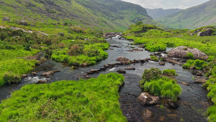 Flying over river in valley between mountains Killarney National Park, Ireland, County Kerry. Nature of Ring of Kerry, Ireland. Aerial shot