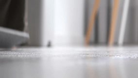 A woman in home clothes is carefully mopping a white floor with a mop. The movement of the mop. Background for cleaning topics, household chores, and cleaning services. - Powered by Shutterstock - Get 15% off with code: PIKWIZARD15